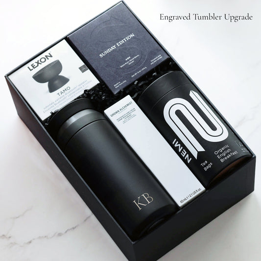 The contents of the Elite Retreat gift box including a monogrammed Kinto tumbler. Items in box on a marble surface.