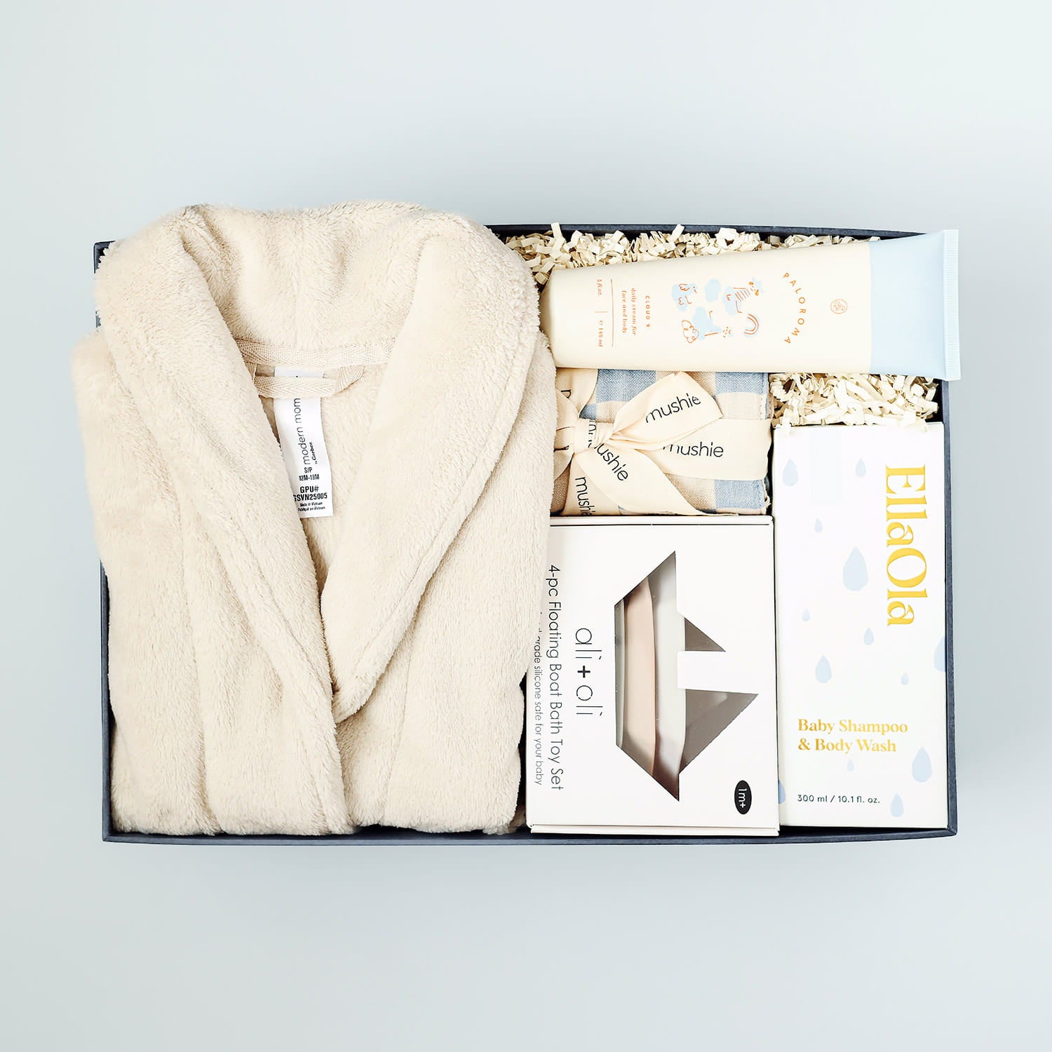 Baby bath gift set with robe, cloths, and bottles in a box on a light gray blue background