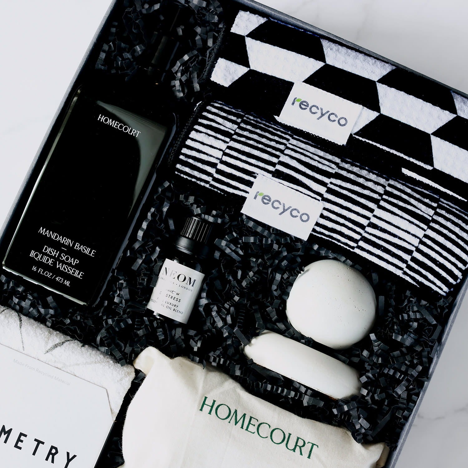 close up of a gift box containing black and white themed eco-friendly home cleaning supplies.