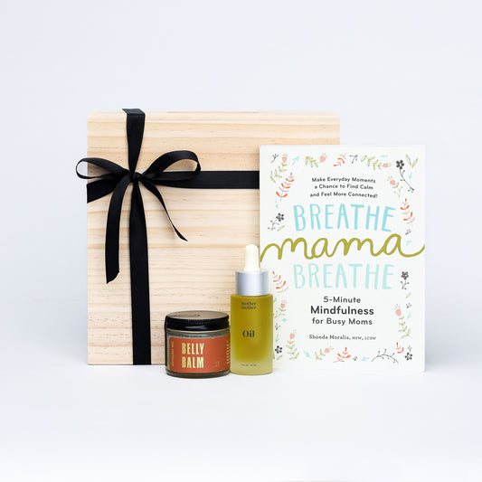 Expecting mother gift set with belly balm, oil, and mindfulness book on a white background
