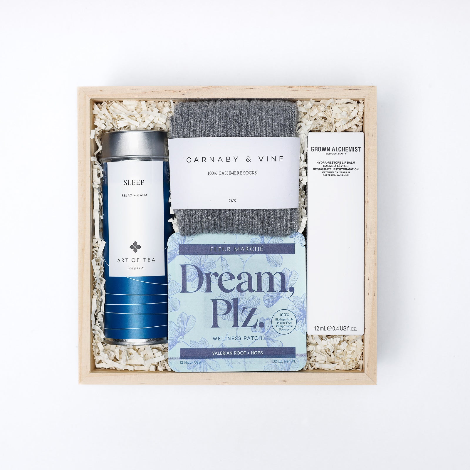 Gift set with tea, socks, and wellness patch in a wooden box on a white background