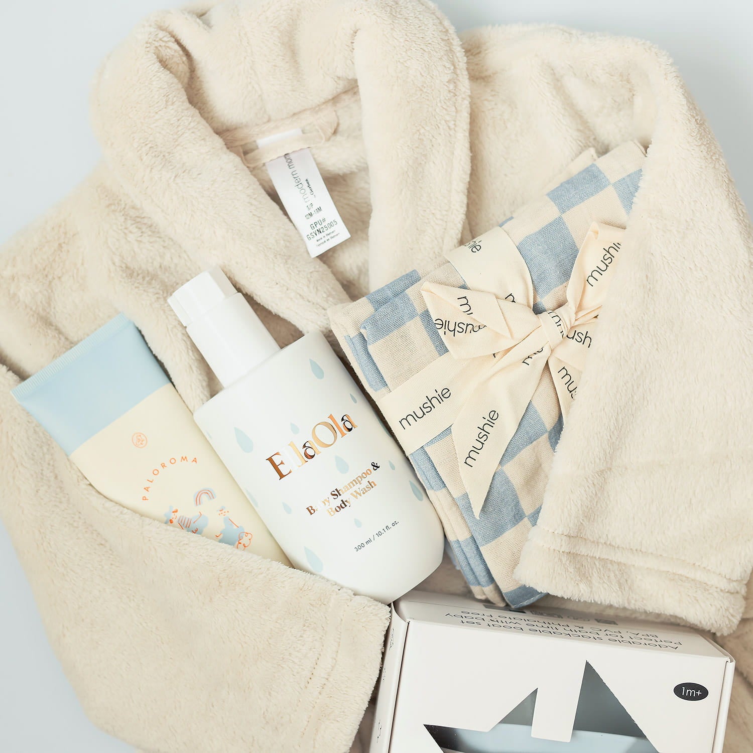 Baby bath products including shampoo, washcloths, lotion, toys on a light gray background